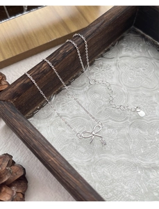 Gros plan détaillé du pendentif nœud en argent sterling S925 avec de petits diamants