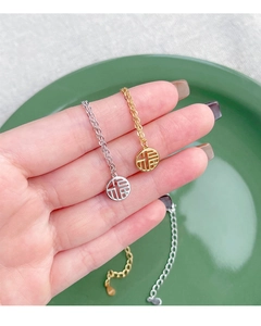 Detail of S925 sterling silver Fu character pendants in gold and silver finish