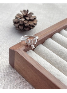 Macro shot of S925 sterling silver bow ring with lily of the valley floral charm detail