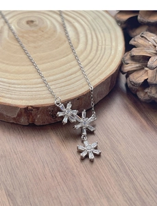 Close-up of S925 silver necklace with three snowflake pendants on natural wood