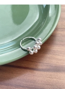 Detail of S925 sterling silver grape cluster ring on green ceramic dish background