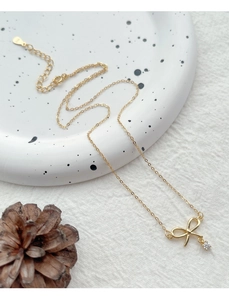 Gros plan du collier en argent S925 avec pendentif nœud, zircon et poinçon de métal