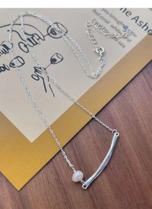 Detail of S925 silver necklace with Freedom engraved metal tube and freshwater pearl