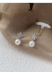 Dettaglio orecchino a fiore in argento S925 con zirconi e perla bianca rotonda