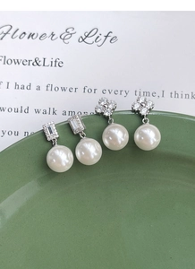 Détail de boucles d'oreilles trèfle en argent S925 avec diamants et perles blanches 10mm