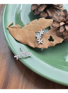 Detailed macro view of S925 silver flower stud earrings with marquise-cut white zircons