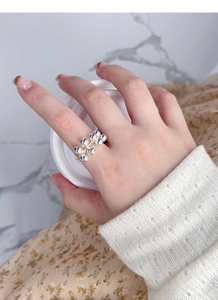 Close-up of S925 sterling silver beaded ring on model finger against marble background