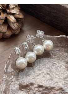 Détail des boucles d'oreilles trèfle en argent S925 avec perles et zircons cubiques