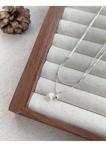 Dettaglio della collana doppia catena snake in argento S925 con perla e sfera metallica