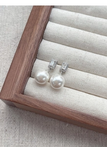 Détail de boucle d'oreille en argent S925 avec zircone carrée et perle blanche pendante