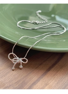 Détail du collier avec pendentif nœud en argent S925 et chaîne serpent élégante