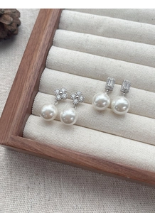 Vue détaillée de boucles d'oreilles trèfle en argent S925 avec diamants et perles