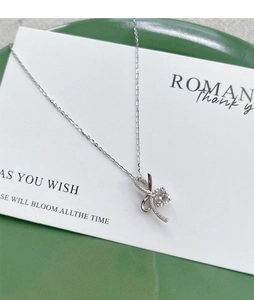 Détail macro du pendentif nœud en argent S925 avec un diamant central étincelant