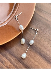 Vue détaillée d'élégantes boucles d'oreilles S925 en argent avec perles d'eau douce sur plat