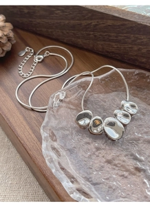 Detailed macro shot of S925 sterling silver snake chain with irregular mirror pendants