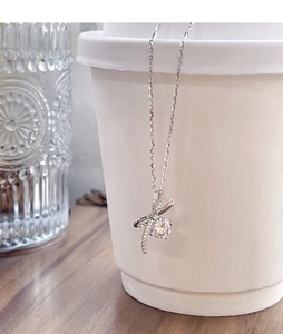 Gros plan du pendentif nœud en argent avec pierre centrale sur une tasse à café