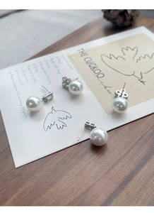 Détail de boucles d'oreilles trèfle en argent S925 avec perle et zircon sur carte