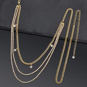 Détail de la chaîne de taille dorée multicouche avec étoiles en strass et fermoir homard