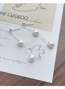 Détail de boucles d'oreilles en argent S925 avec perles d'eau douce et pompons en chaîne
