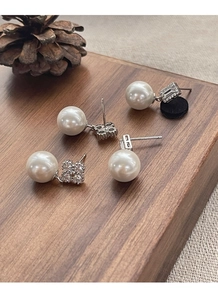 Détail de boucles d'oreilles perles en argent S925 avec zircons carrés et motif trèfle