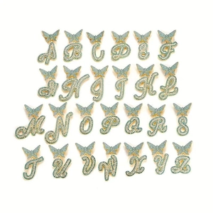Iced out alphabet necklaces with green zircons and butterfly clasp detail on white background