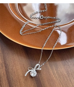 Détail du collier noeud en argent S925 avec pendentif en zircon brillant sur assiette céramique