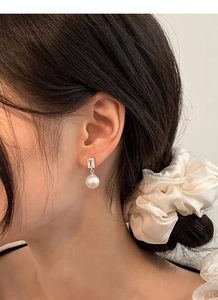 Vue détaillée des boucles d'oreilles perles en argent S925 et cristaux pavés
