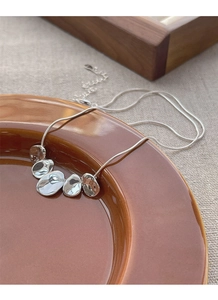 Detail of silver S925 snake chain necklace with five irregular polished metal pendants