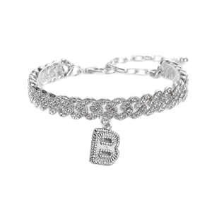 Détail d'une chevillère gourmette argentée avec pendentif lettre B serti de strass