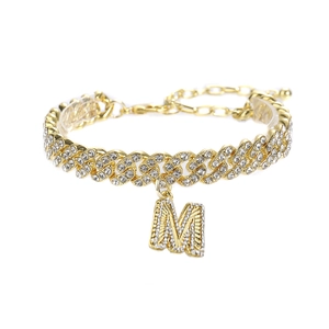Détail de la chevillère cubaine dorée avec pendentif lettre M texturé et zircons