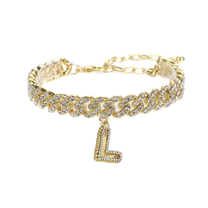 Détail d'une chevillère gourmette dorée ornée d'un pendentif lettre L serti de cristaux