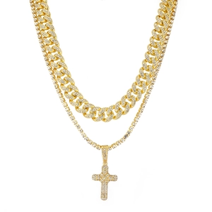 Close-up of hip hop gold Cuban link and tennis chain with iced out cross pendant