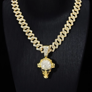 Close-up of gold-plated hip hop skull pendant with rhinestones on a Cuban chain