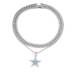 Gros plan du collier hip hop superposé avec pendentif étoile glacé et chaîne cubaine