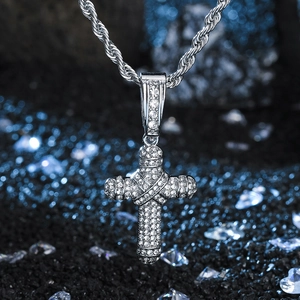 Macro shot of silver hip-hop cross pendant with micro-paved crystals on twisted rope chain