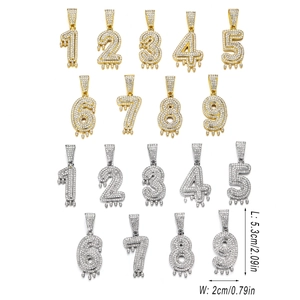 Détails macro des pendentifs chiffres glacés avec design goutte en or et argent