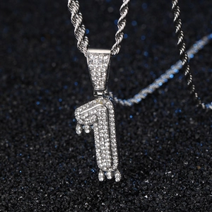 Gros plan du pendentif argenté numéro 1 avec strass et effet gouttelette de liquide