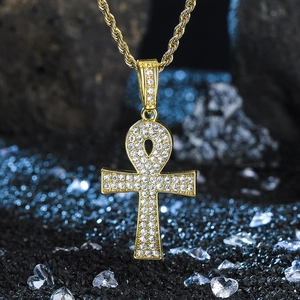 Close-up of gold-plated Ankh cross pendant with sparkling rhinestones on twisted rope chain