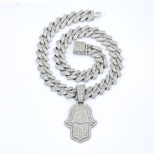Détail du pendentif Main de Fatma serti de strass sur une chaîne à maillons cubains