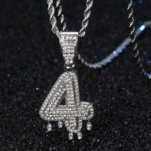 Vue macro détaillée du pendentif chiffre 4 argenté serti de strass avec chaîne hip-hop