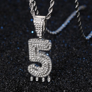 Détail du pendentif argent chiffre 5 avec effet goutte et strass sur une chaîne torsadée
