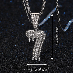 Détail du pendentif numéro 7 serti de strass avec une chaîne torsadée