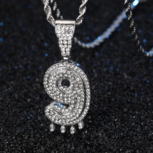 Vue macro du pendentif chiffre 9 hip hop en argent avec strass sur chaîne corde