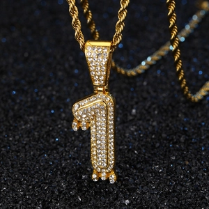 Macro détaillée du pendentif chiffre 1 doré avec strass sur chaîne de corde tordue