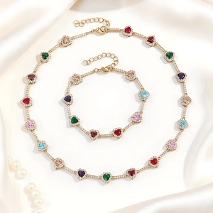 Vista detallada de collar tennis dorado y conjunto de pulsera con circonitas de colores