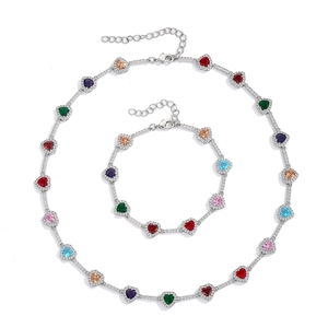Detalle de collar y pulsera con circonitas de colores en forma de corazón y baño de plata