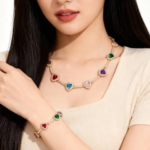 Primer plano de un conjunto de collar y pulsera de tenis con circonitas de corazones de colores