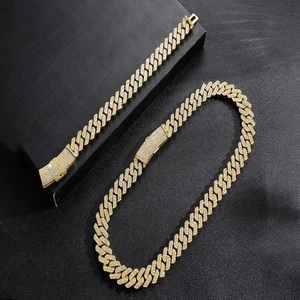 Parure collier et bracelet gourmette dorés glacés avec strass sur fond noir élégant