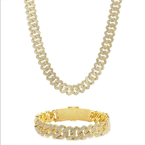 Détail du lot de collier et bracelet gourmette dorés avec strass de style hip hop luxe