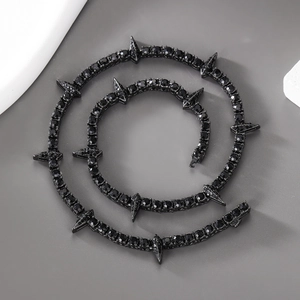 Macro view of black punk style spiky necklace with dense dark rhinestones and metal spikes
